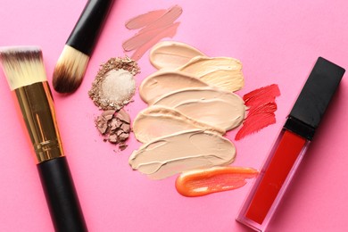 Photo of Different cosmetic products and makeup brushes on magenta background, flat lay