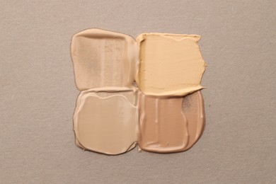 Photo of Colorful skin foundations on grey background, flat lay