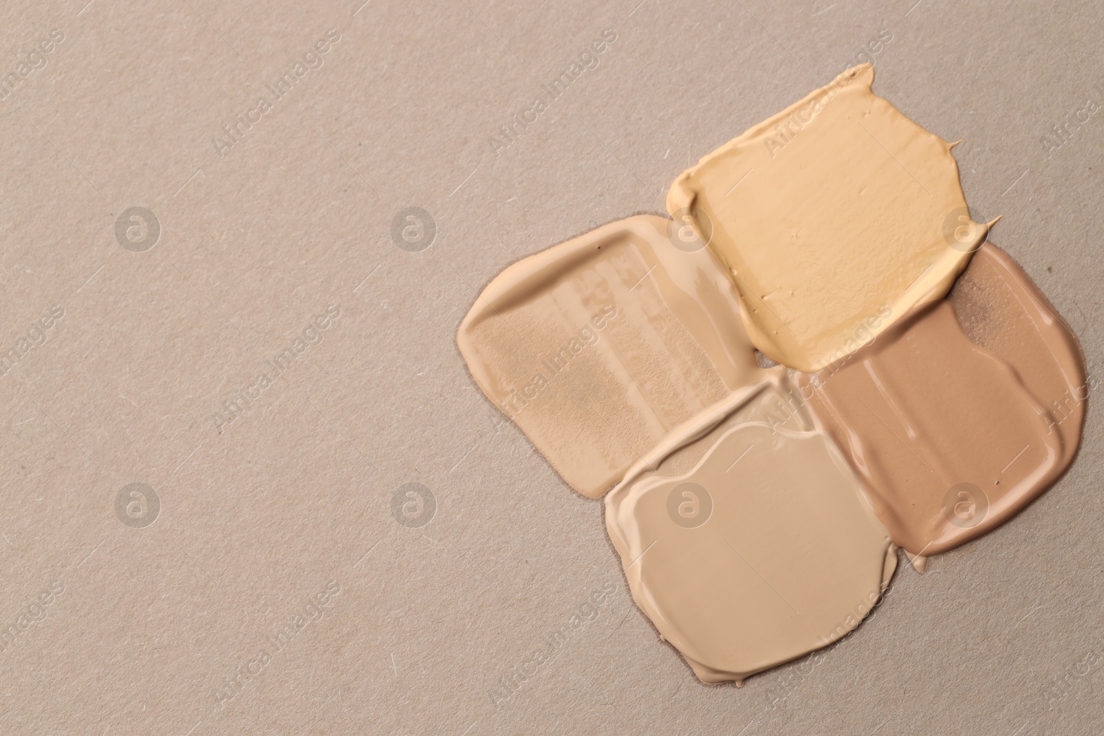 Colorful skin foundations on grey background, flat lay. Space for text Photo of Colorful skin foundations on grey background, flat lay. Space for text