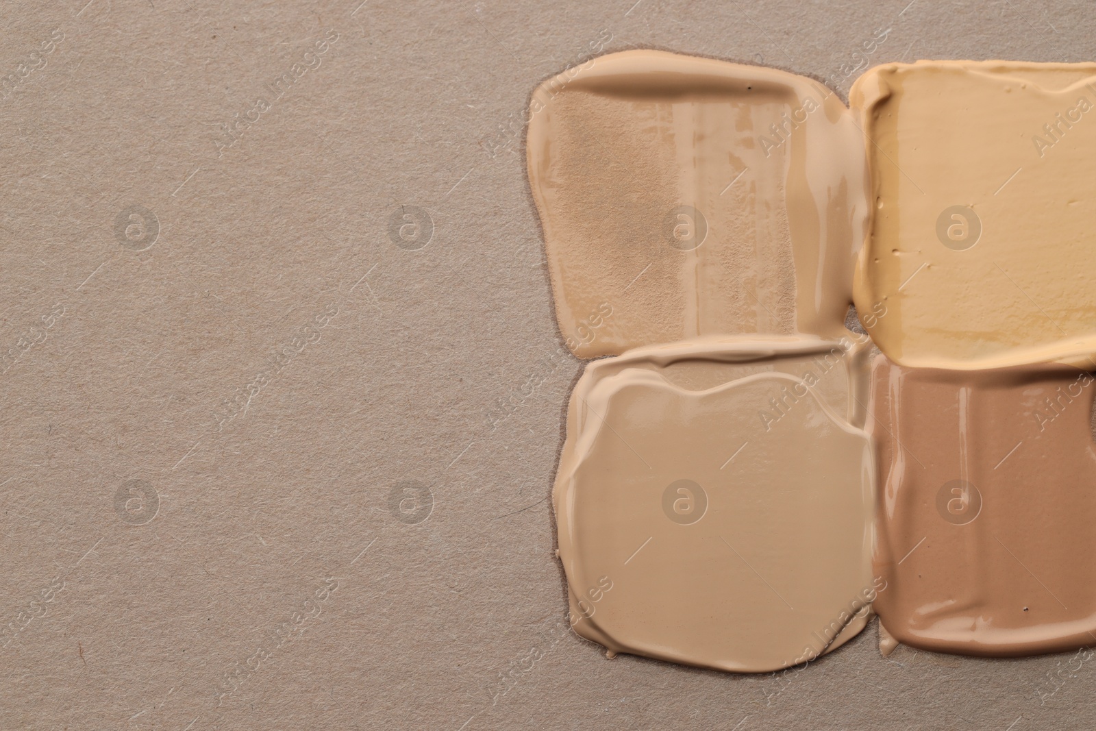 Colorful skin foundations on grey background, flat lay. Space for text Photo of Colorful skin foundations on grey background, flat lay. Space for text