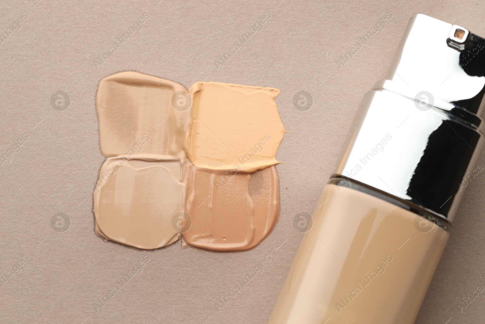 Colorful skin foundations and bottle on grey background, flat lay Photo of Colorful skin foundations and bottle on grey background, flat lay