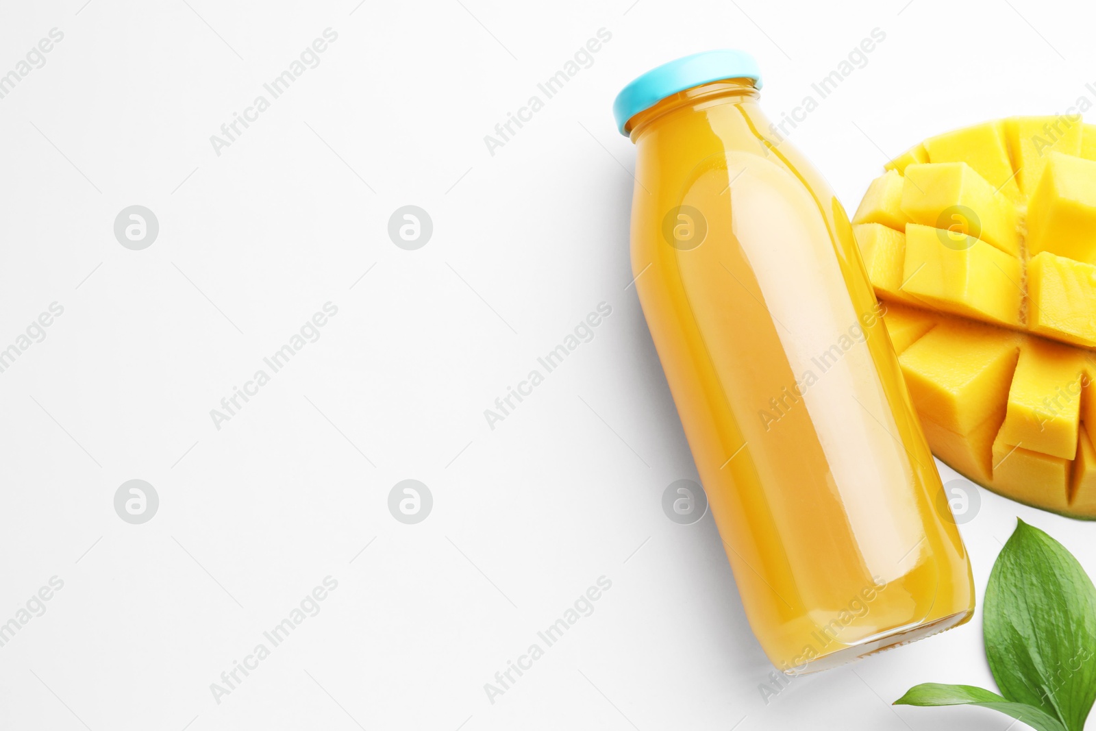 Tasty mango juice in glass bottle, fresh fruit and leaves on white background, flat lay. Space for text Photo of Tasty mango juice in glass bottle, fresh fruit and leaves on white background, flat lay. Space for text