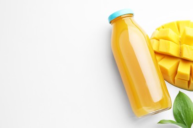 Photo of Tasty mango juice in glass bottle, fresh fruit and leaves on white background, flat lay. Space for text