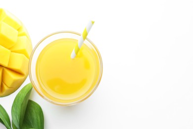 Photo of Tasty mango juice in glass, fresh fruit and green leaves on white background, flat lay. Space for text