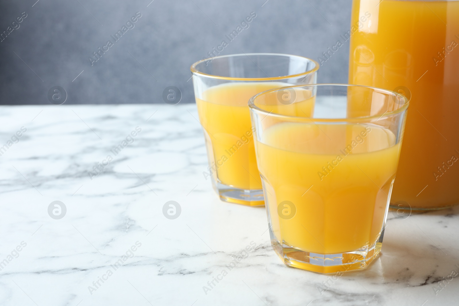 Tasty mango juice in glasses on white marble table, closeup. Space for text Photo of Tasty mango juice in glasses on white marble table, closeup. Space for text