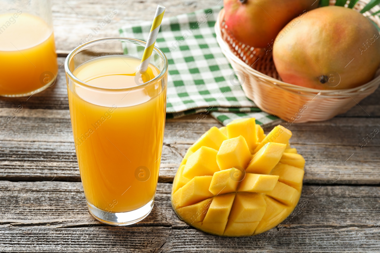 Tasty mango juice in glass and fresh fruits on wooden table, closeup Photo of Tasty mango juice in glass and fresh fruits on wooden table, closeup