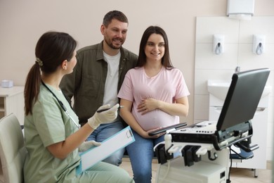 Photo of Pregnant couple attending prenatal ultrasound examination in clinic