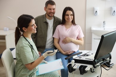 Photo of Pregnant couple attending prenatal ultrasound examination in clinic