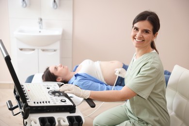 Photo of Sonographer conducting woman's prenatal ultrasound examination in clinic