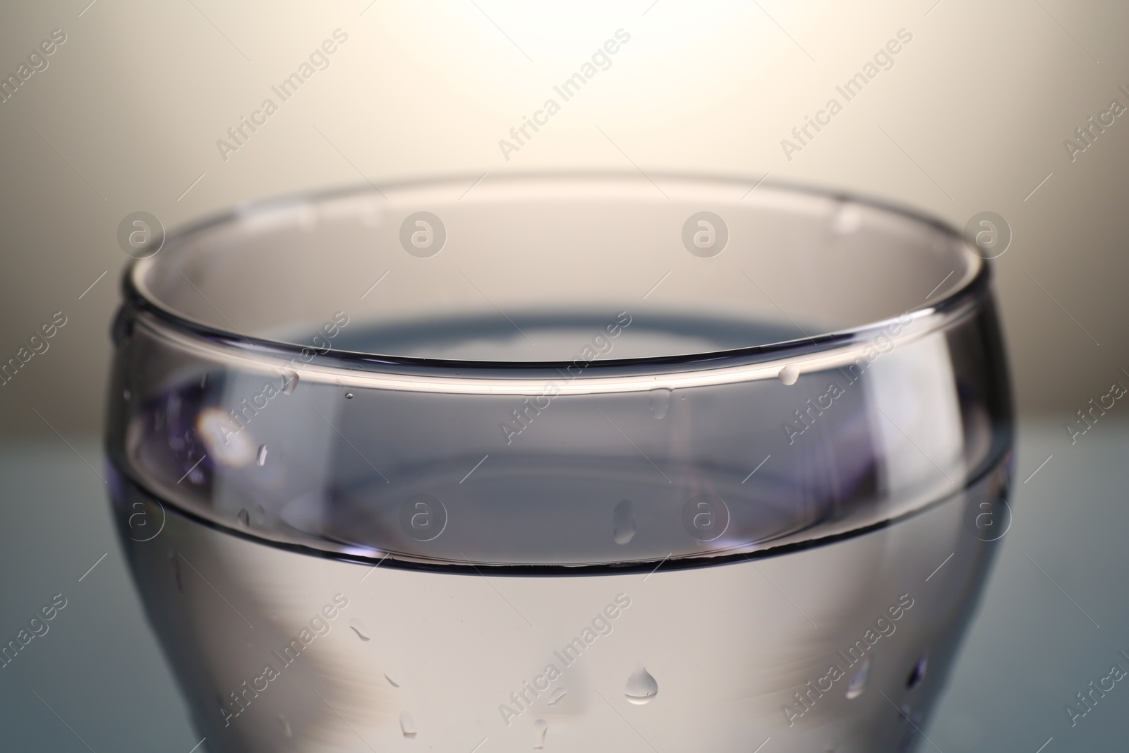Fresh water in glass on gray gradient background, closeup Photo of Fresh water in glass on gray gradient background, closeup