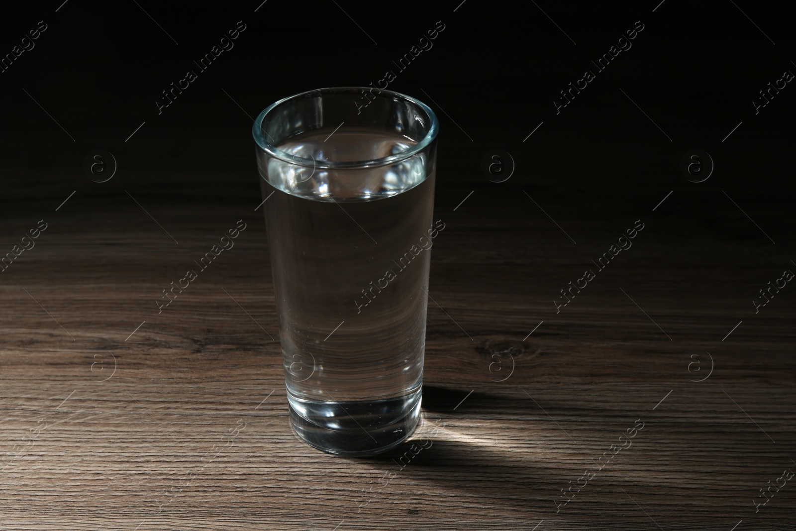Fresh water in glass on wooden table Photo of Fresh water in glass on wooden table