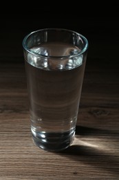 Photo of Fresh water in glass on wooden table, closeup