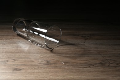 Photo of Overturned glass and spilled water on wooden table