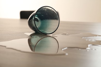 Photo of Overturned glass and spilled water on table