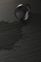 Photo of Overturned glass and spilled water on wooden table