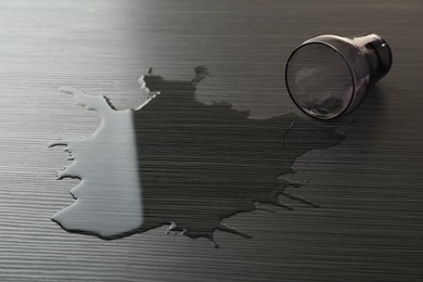Photo of Overturned glass and spilled water on wooden table