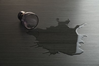Photo of Overturned glass and spilled water on wooden table