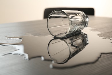 Photo of Overturned glass and spilled water on table