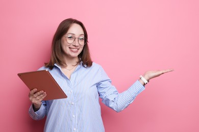 Photo of Woman with modern tablet on pink background. Space for text