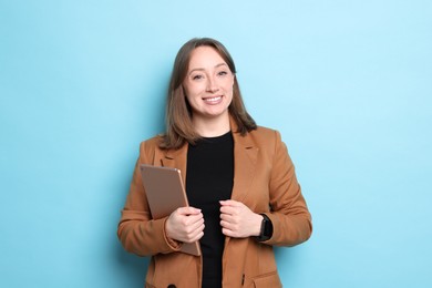 Photo of Woman with modern tablet on light blue background