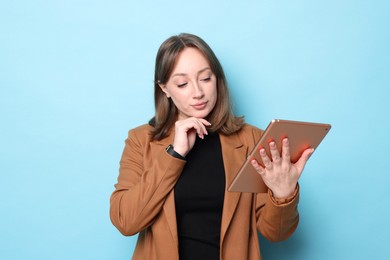 Photo of Woman with modern tablet on light blue background