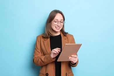 Photo of Woman with modern tablet on light blue background