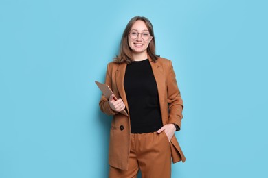 Photo of Woman with modern tablet on light blue background