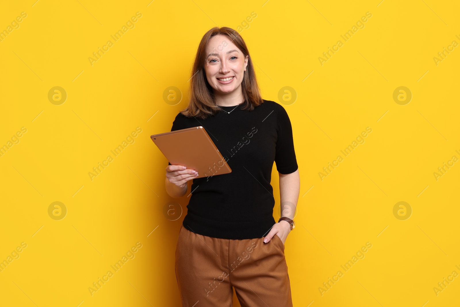 Photo of Woman with modern tablet on orange background