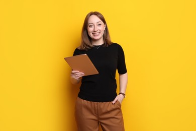 Photo of Woman with modern tablet on orange background