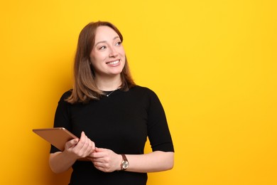 Photo of Woman with modern tablet on orange background, space for text