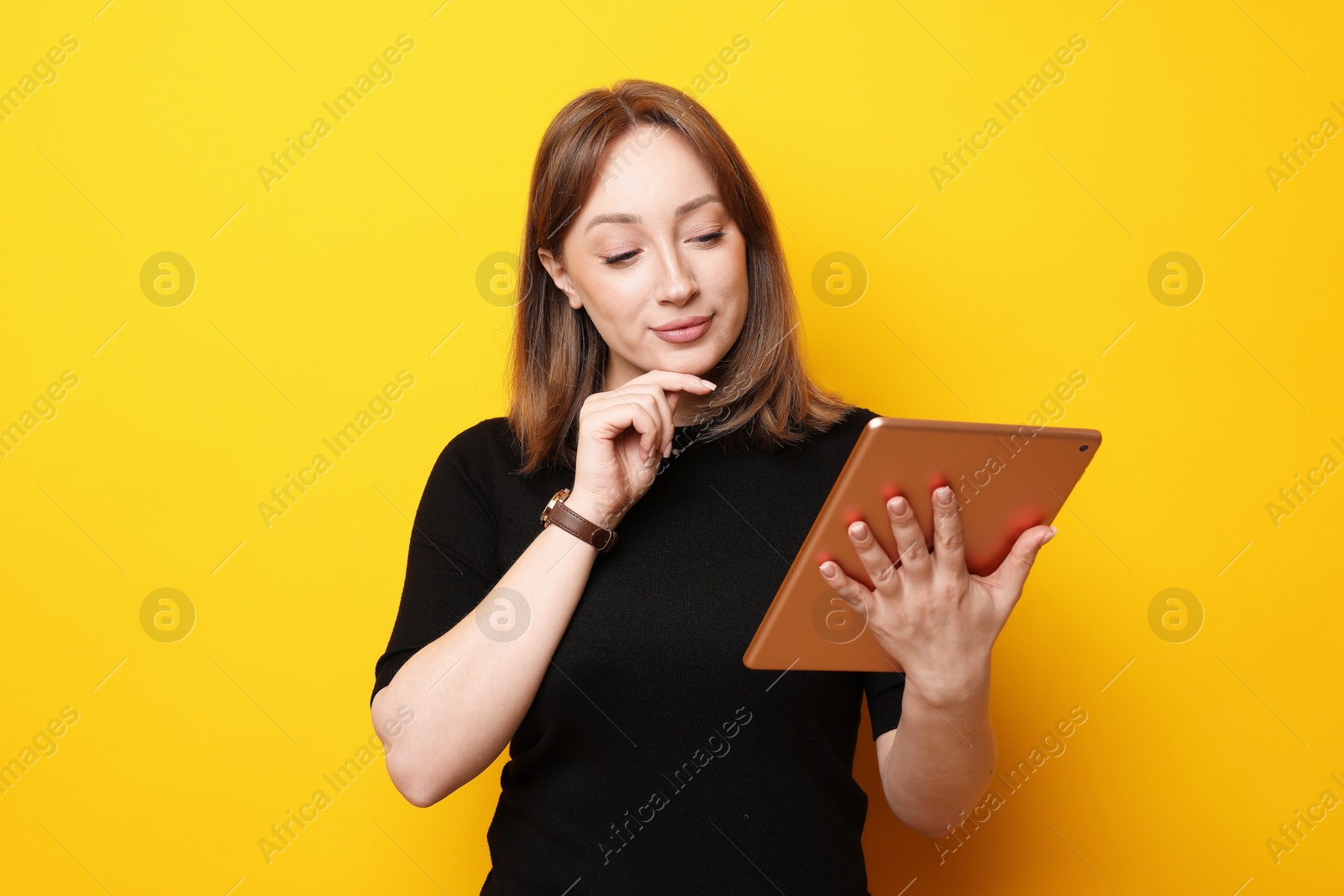 Photo of Woman with modern tablet on orange background