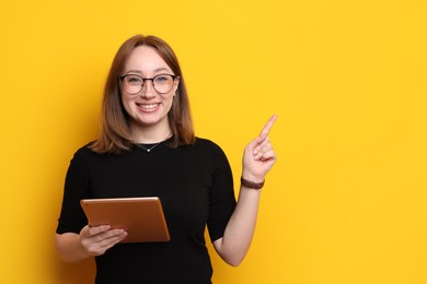 Photo of Woman with modern tablet on orange background, space for text