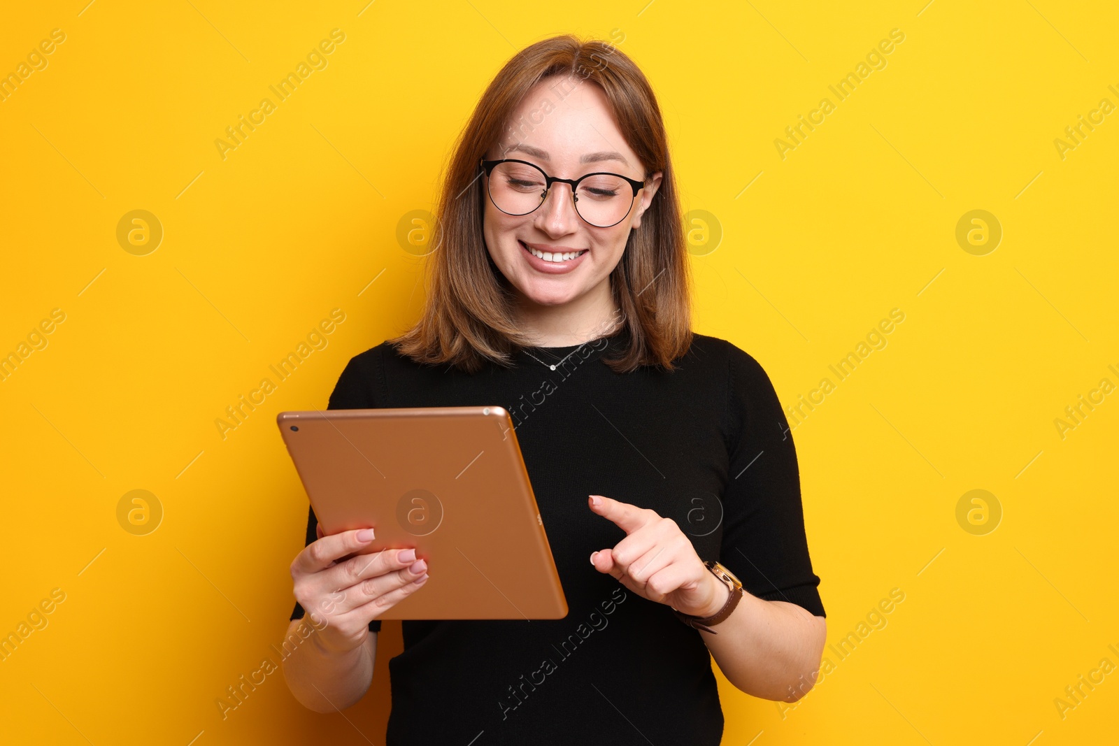 Photo of Woman with modern tablet on orange background