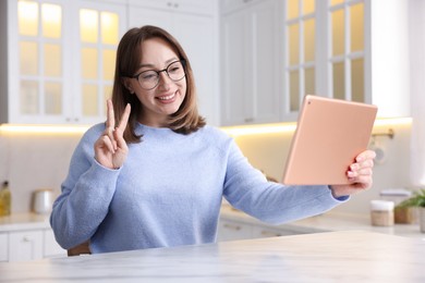 Photo of Woman taking selfie at white marble table in kitchen