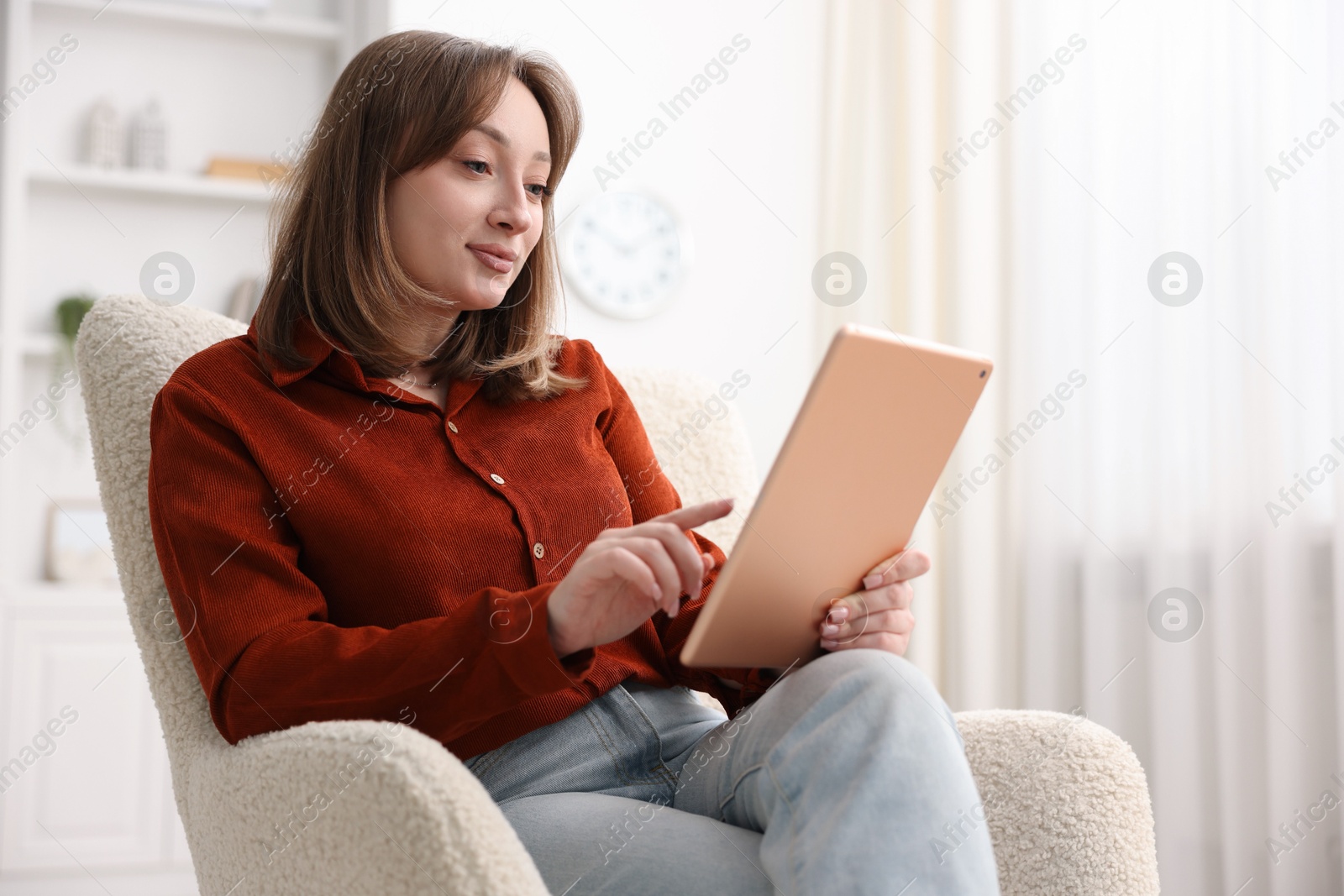 Photo of Woman with modern tablet in armchair at home