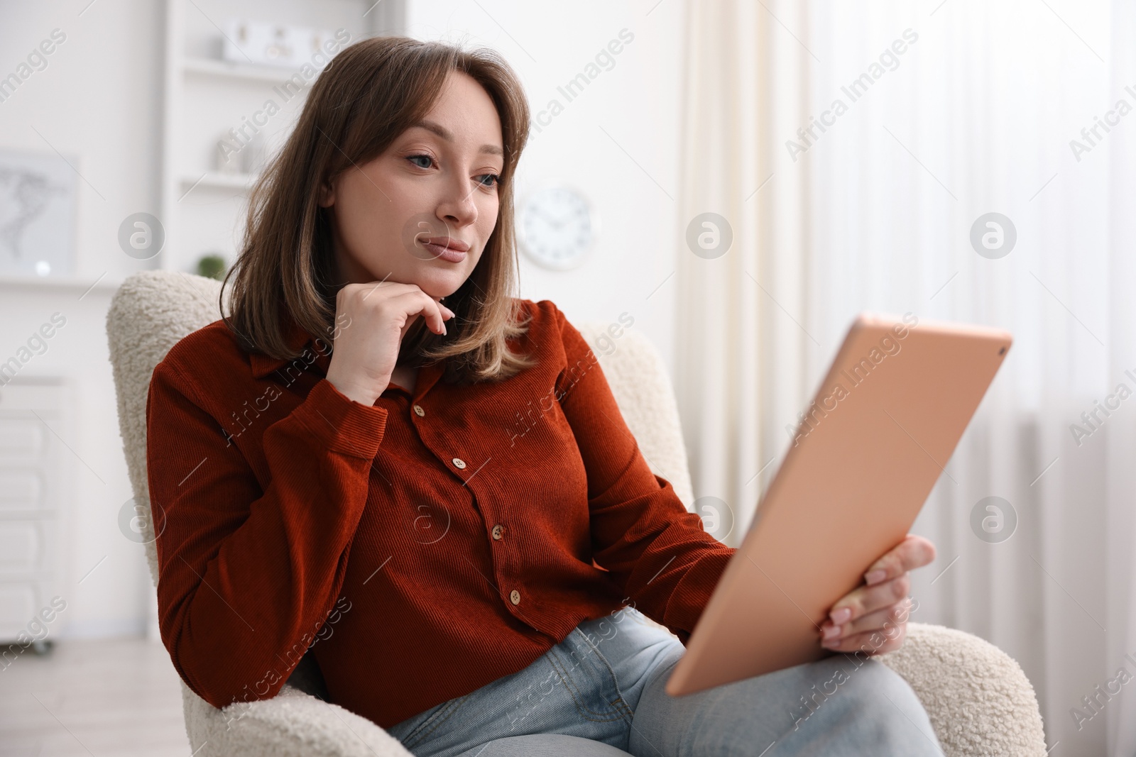 Photo of Woman with modern tablet in armchair at home