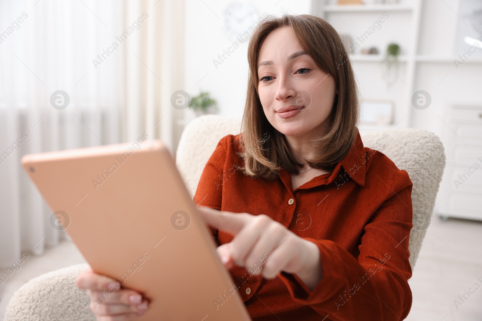 Photo of Woman with modern tablet in armchair at home