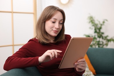 Photo of Woman with modern tablet on sofa at home