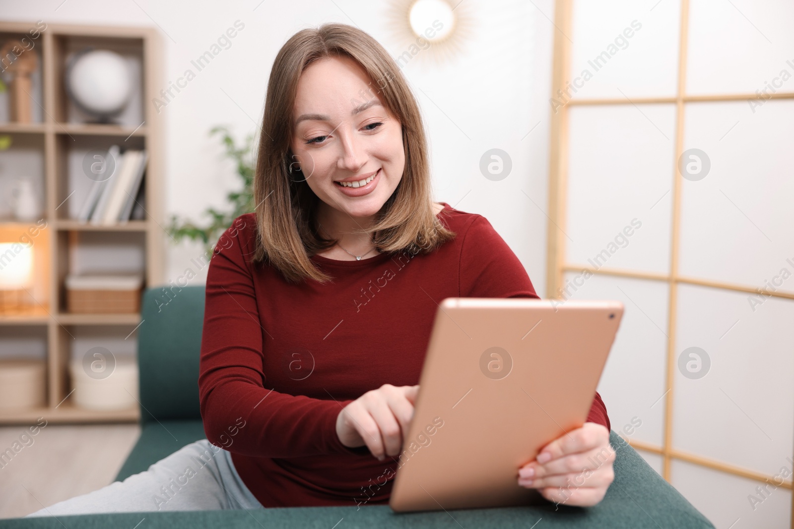 Photo of Woman with modern tablet on sofa at home