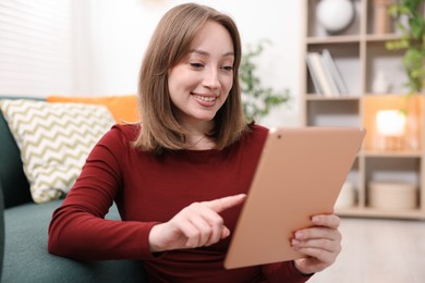 Photo of Woman with modern tablet on floor at home