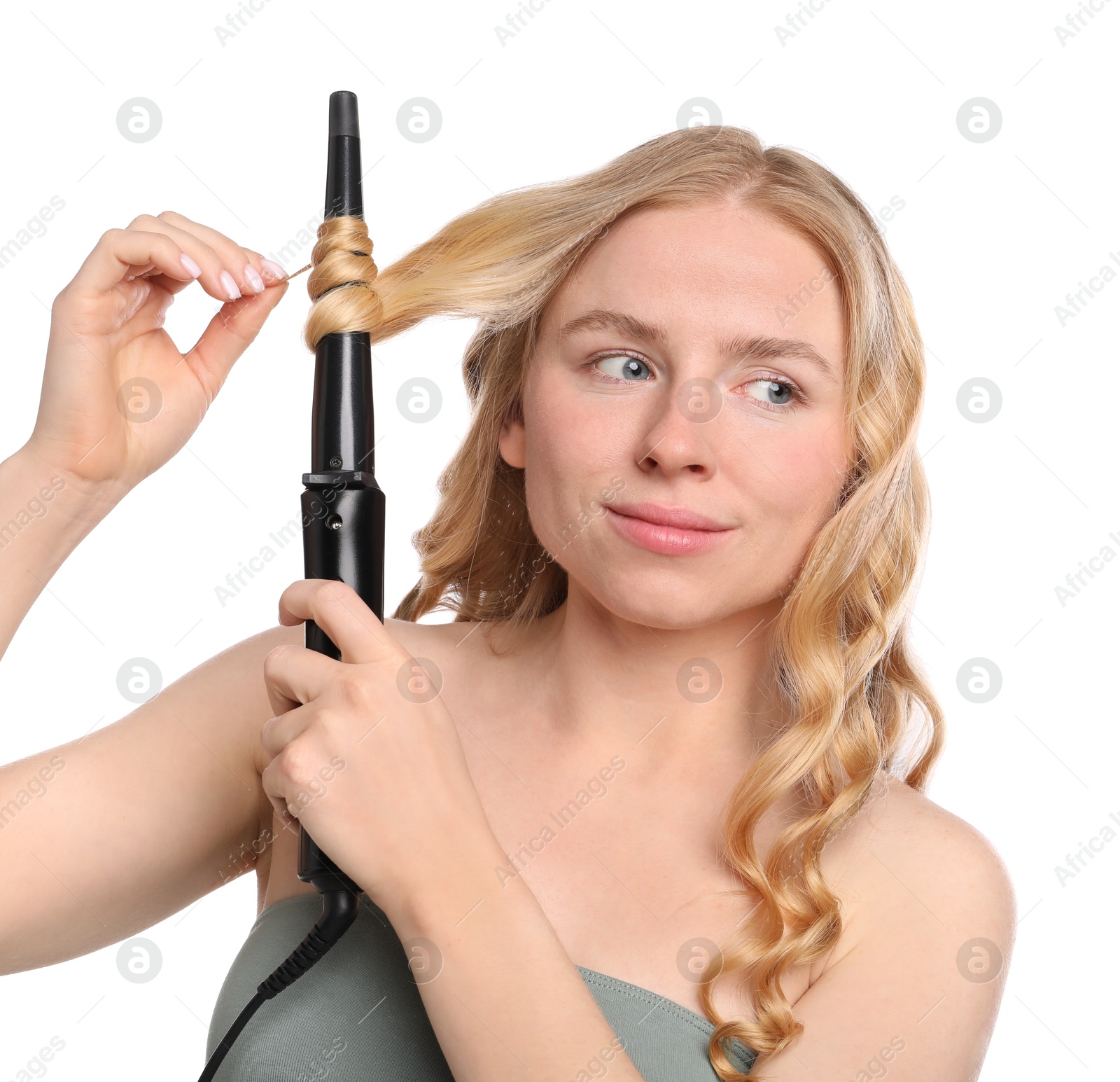 Photo of Woman curling her hair on white background