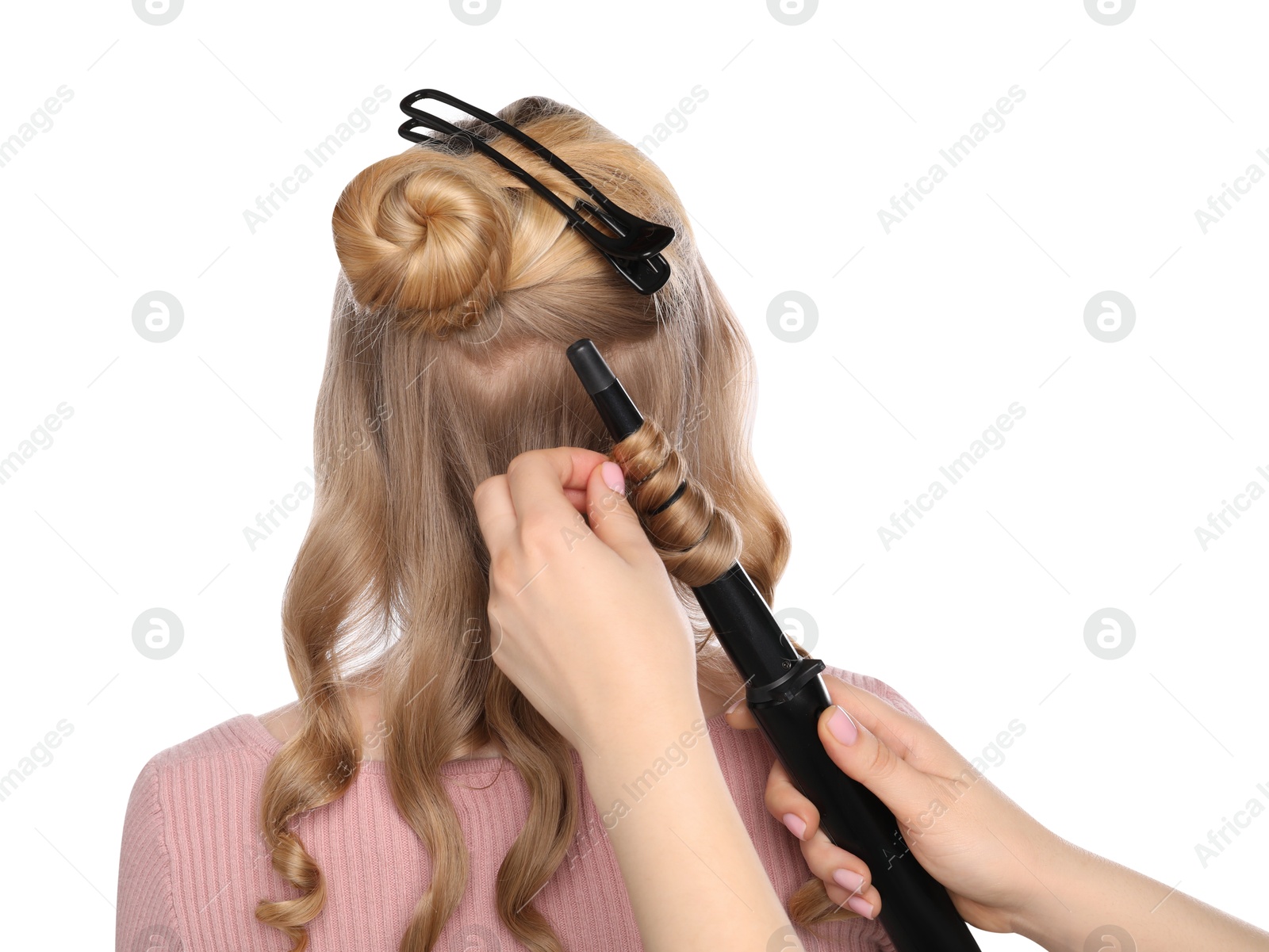 Photo of Hairdresser curling woman's hair on white background, back view