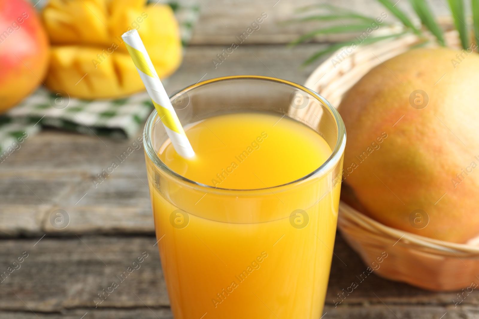 Tasty mango juice in glass and fresh fruits on table, closeup Photo of Tasty mango juice in glass and fresh fruits on table, closeup