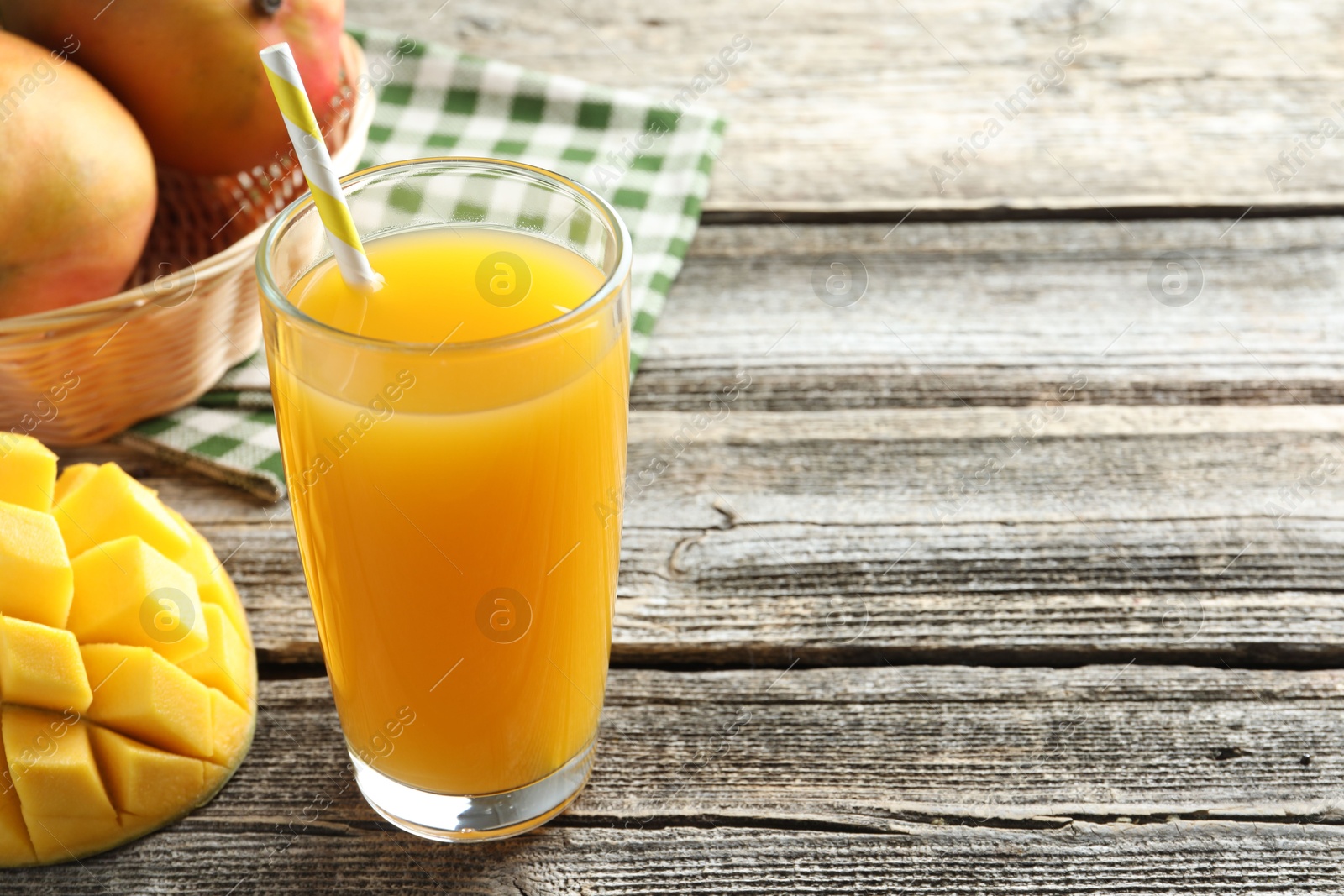 Tasty mango juice in glass and fresh fruits on wooden table, closeup. Space for text Photo of Tasty mango juice in glass and fresh fruits on wooden table, closeup. Space for text