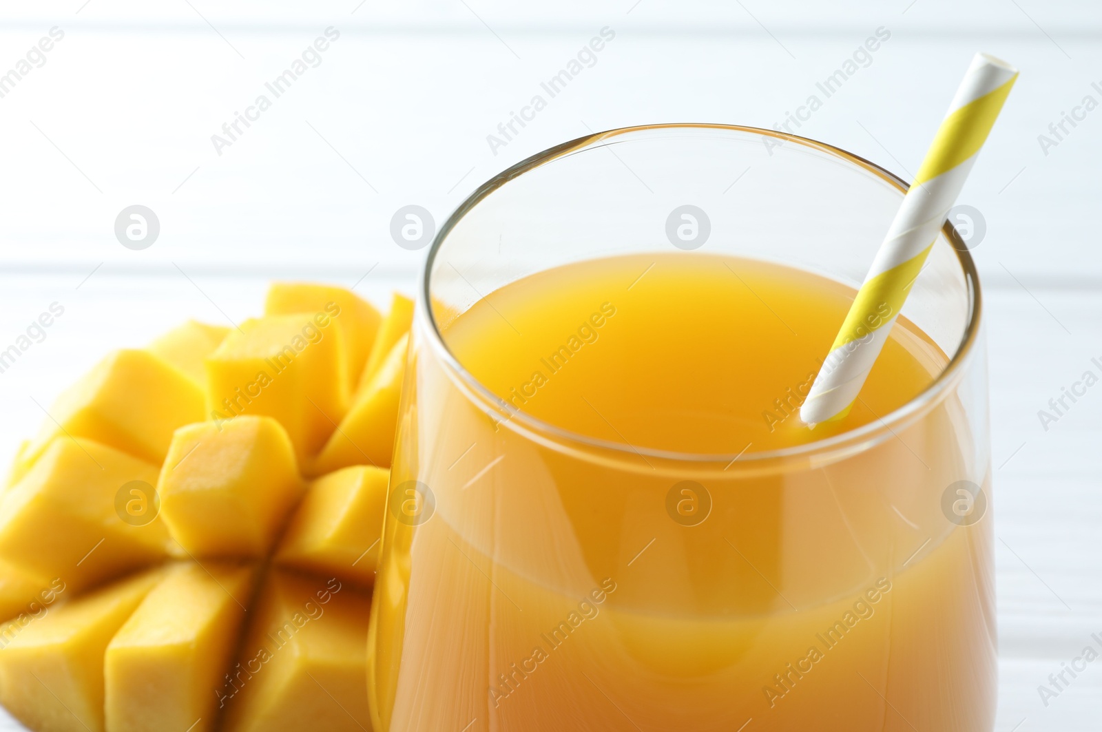 Tasty mango juice in glass and fresh fruit on white table, closeup Photo of Tasty mango juice in glass and fresh fruit on white table, closeup