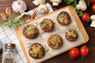 Photo of Delicious stuffed mushrooms and products on wooden table, flat lay