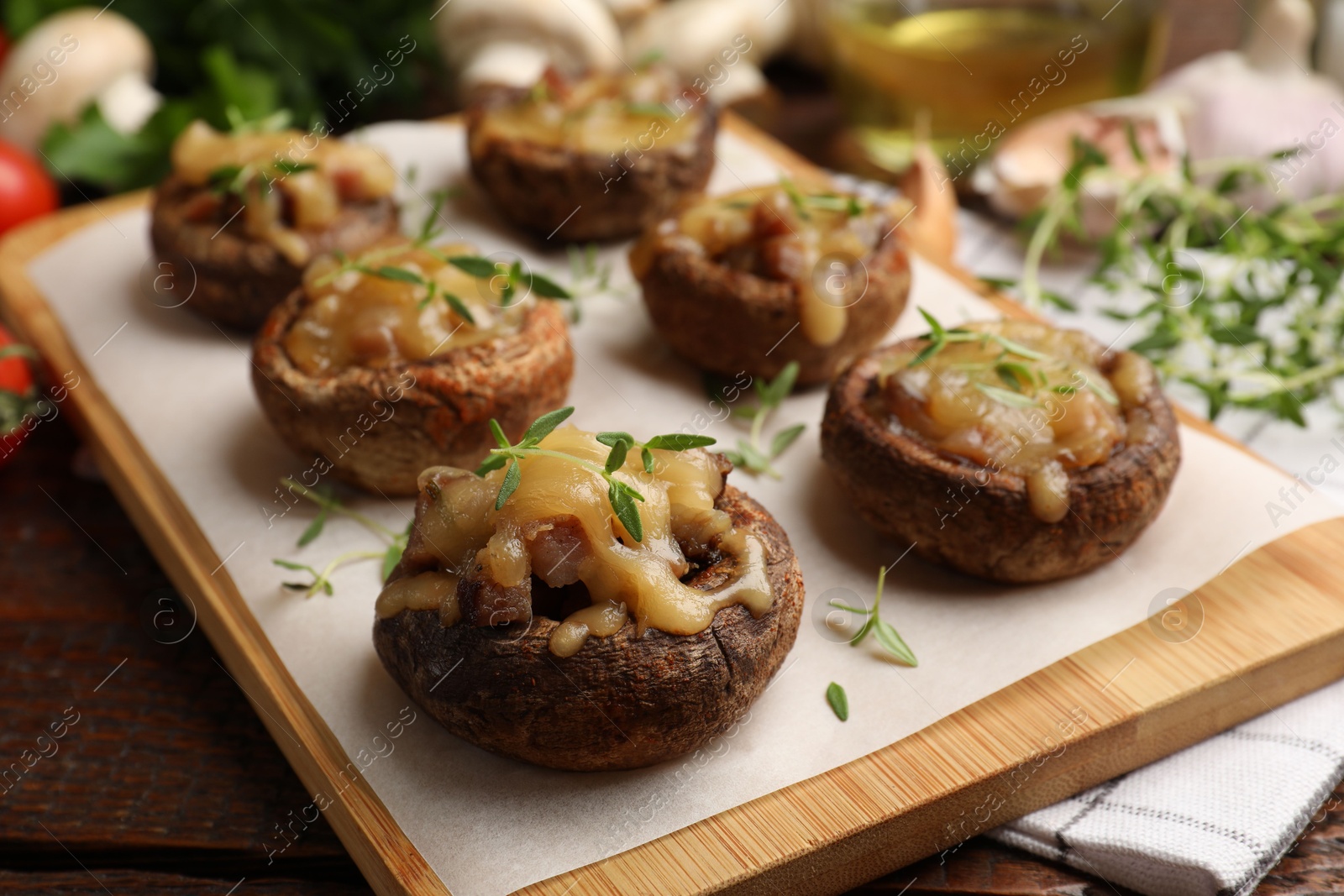Delicious stuffed mushrooms with melted cheese and thyme on wooden table, closeup Photo of Delicious stuffed mushrooms with melted cheese and thyme on wooden table, closeup
