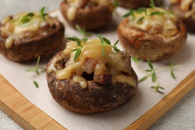 Photo of Delicious stuffed mushrooms with melted cheese and thyme on grey table, closeup