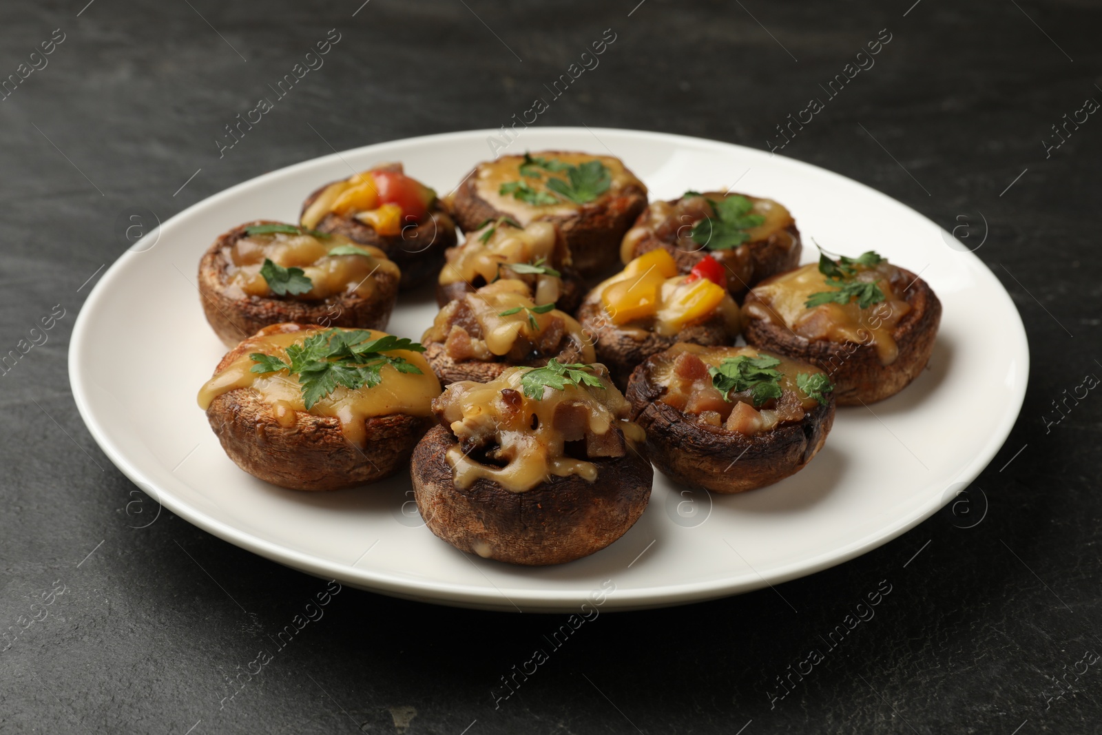 Tasty stuffed mushrooms on black table, closeup Photo of Tasty stuffed mushrooms on black table, closeup