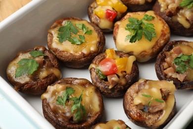 Photo of Tasty stuffed mushrooms in baking dish, above view
